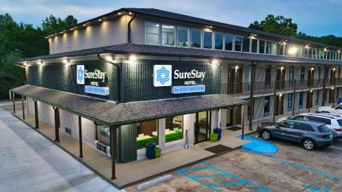 a building with a car parked in a parking lot at SureStay Hotel by Best Western Jasper in Jasper