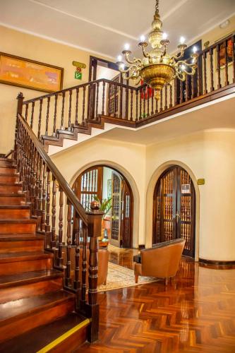 a staircase in a home with a chandelier at Best Western Plus Hotel Stofella in Guatemala