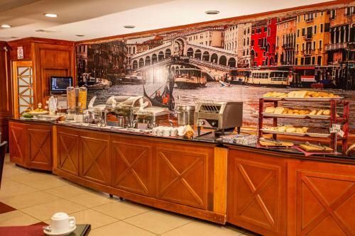 a breakfast counter with a mural of a city at Best Western Plus Hotel Stofella in Guatemala