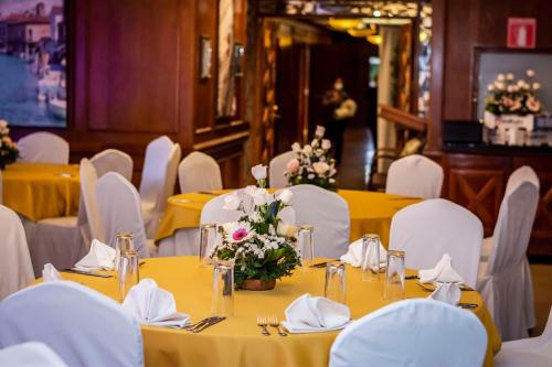 a dining room with yellow tables and white chairs at Best Western Plus Hotel Stofella in Guatemala