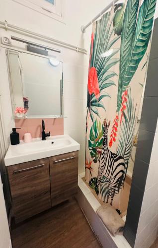 La salle de bains est pourvue d'un lavabo et d'un rideau de douche avec un zèbre. dans l'établissement Appart l'Echappée Belle, Centre Historique, Gare, à Montpellier