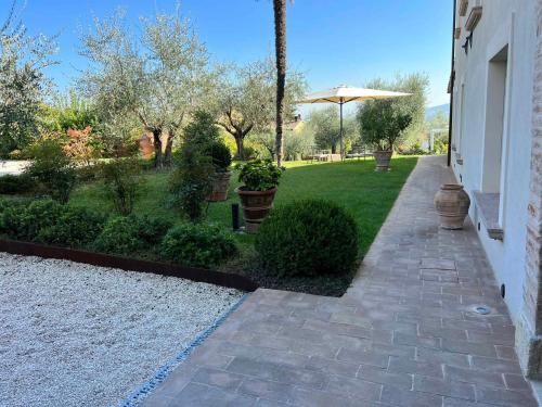 a walkway leading to a yard with an umbrella at Holiday Homes in Perugia - Umbrien 50687 in Perugia