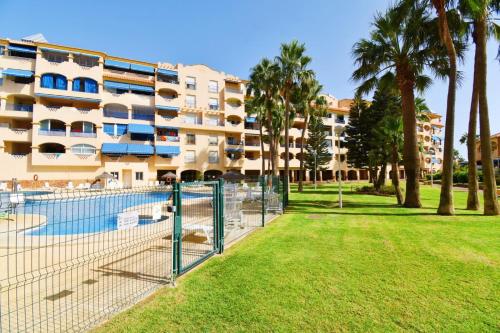 a large apartment building with a tennis court in a park at Expoholidays - Estudio a pie de playa in Almerimar