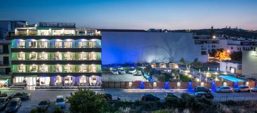 a large building in a parking lot at night at Infinity Blue Boutique Hotel & Spa - Adults Only in Hersonissos