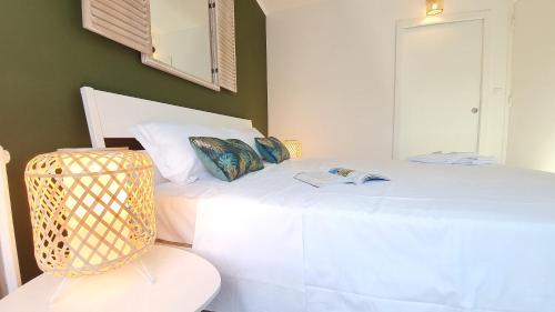 - une chambre avec un lit blanc et un livre dans l'établissement Tour du Guet 2, à Calais