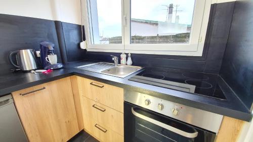 une petite cuisine avec un évier et une fenêtre dans l'établissement Tour du Guet 2, à Calais