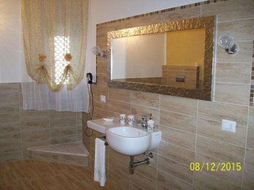 a bathroom with a sink and a mirror at Domos Le Due Tuie in Piscinas