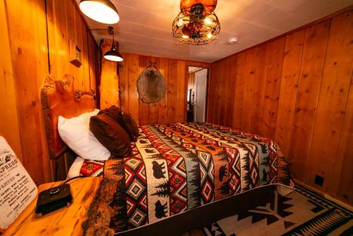 a bedroom with a bed in a room with wooden walls at Chinook Winds Lodge in Dubois
