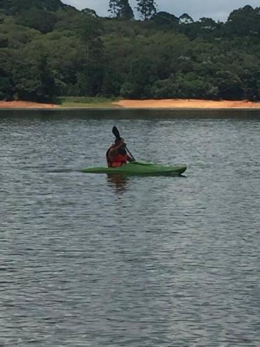 a person in a kayak on a body of water at Chácara com acesso à represa in Ibiúna