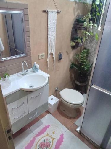a bathroom with a toilet and a sink and a shower at Chácara com acesso à represa in Ibiúna