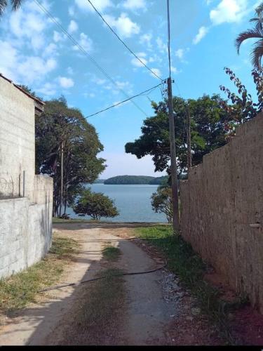 a dirt road with a view of a body of water at Chácara com acesso à represa in Ibiúna