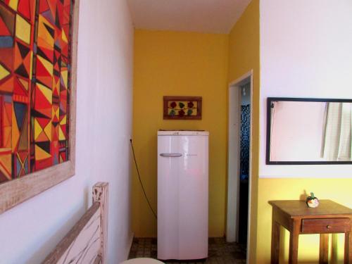 a white refrigerator in a room with a painting at Suíte Frida in Tiradentes
