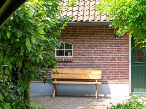 a wooden bench sitting in front of a brick building at de Spil in Winterswijk-Meddo