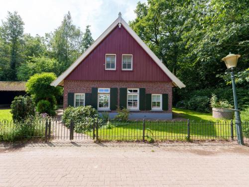 a red house with a fence in front of it at de Spil in Winterswijk-Meddo