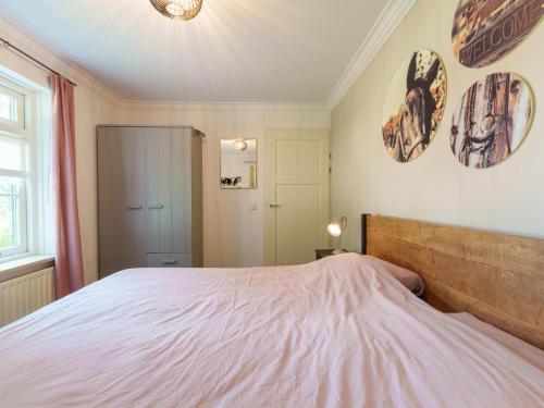 a bedroom with a large bed and two pictures on the wall at de Spil in Winterswijk-Meddo