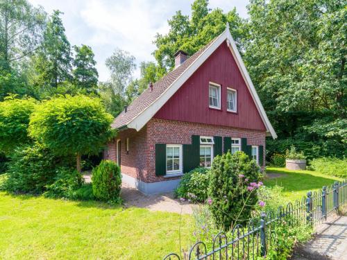 a red and green house with a fence at de Spil in Winterswijk-Meddo