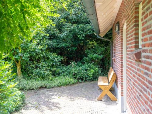 a wooden bench sitting next to a brick building at de Spil in Winterswijk-Meddo