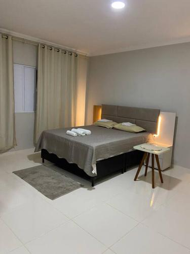 a bedroom with a bed and a table in it at Flat com 1 dormitório in Córrego da Forquiha