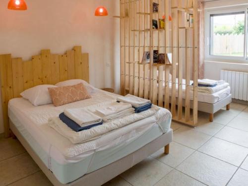 a bedroom with a bed with a wooden headboard at Maison familiale avec piscine chauffée, salle de jeux et grand jardin - 5 chambres, 15 couchages - FR-1-410-340 in Changé