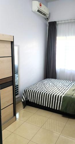 a bedroom with a bed and a window at CozyRizqy Homestay at Kebun Baru - 3R2B in Jenjarum