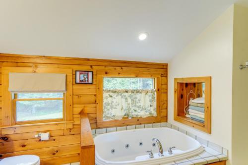 ウィルミントンにあるSpacious Wilmington Cabin Walk to Lakeのバスルーム(バスタブ付)、窓が備わります。