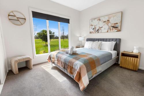 a bedroom with a bed and a large window at Limestone Views in Swan Reach