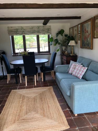 a living room with a couch and a table at The Old Workhouse Paddocks in Bawdeswell