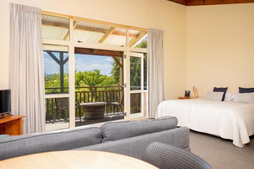 a living room with a bed and a large window at Margrain Vineyard Villas in Martinborough 