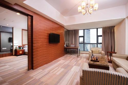 a living room with a couch and a tv at Guangzhou Good International Hotel in Guangzhou