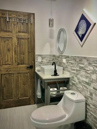 a bathroom with a toilet and a sink at Cabaña Rio Blamco in Guápiles