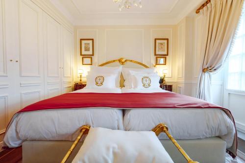 a bedroom with a large bed with red and white pillows at Boutique Hotel Teatro in Angra do Heroísmo
