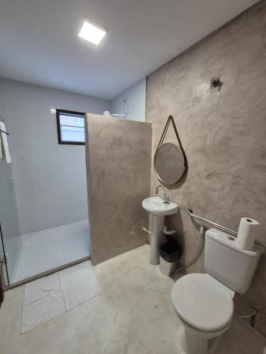 a bathroom with a toilet and a sink and a shower at Santa Areia Lençóis Pousada in Santo Amaro