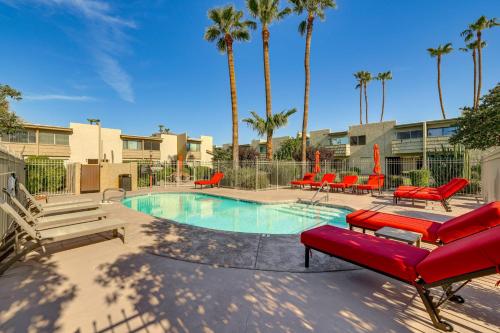 a swimming pool with red furniture and palm trees at Unwind Poolside, Walk to Old Town! Scottsdale Unit in Scottsdale