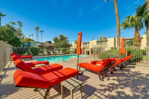 a group of red chairs and umbrellas next to a pool at Unwind Poolside, Walk to Old Town! Scottsdale Unit in Scottsdale