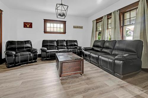 a living room with black leather furniture and a table at Spacious 4BR 1BA near the Falls in Niagara Falls