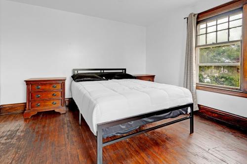 a bedroom with a bed and a dresser and a window at Spacious 4BR 1BA near the Falls in Niagara Falls
