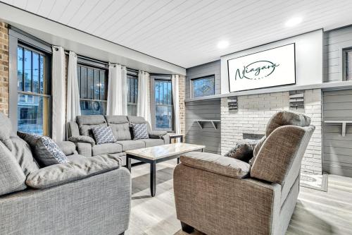 a living room with two couches and a fireplace at Renovated 6BR 2BA Minutes from Falls and Casino in Niagara Falls