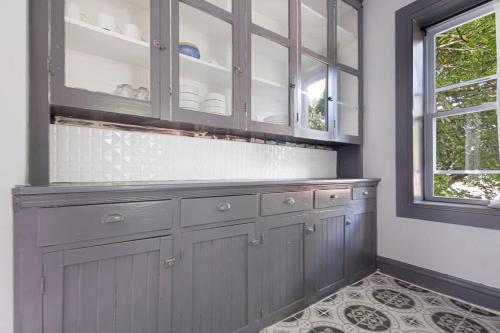 a kitchen with gray cabinets and a window at Cozy 4BR 1BA close to the Falls in Niagara Falls
