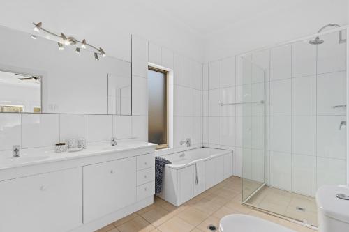 a white bathroom with a tub sink and a toilet at Lambert Estate Retreat in Angaston