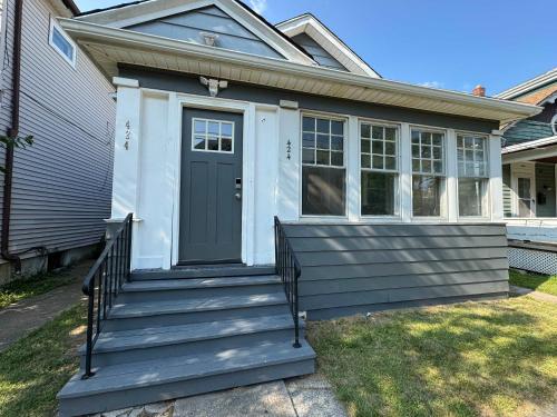 a house with a front porch with a black door at Cozy 3BR 2BA minutes from the Falls in Niagara Falls