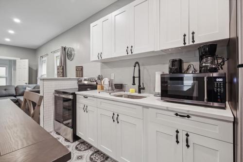 a kitchen with white cabinets and a microwave at Cozy 3BR 2BA minutes from the Falls in Niagara Falls