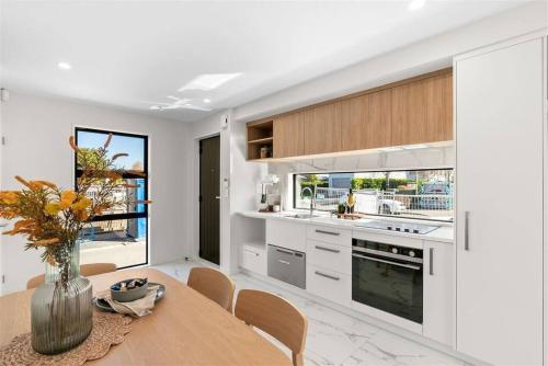 a kitchen with a table with a vase of flowers at 2-bedroom ensuite, close to city, comfortable, accessible with own parking in Christchurch
