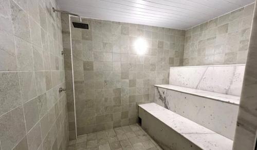 a bathroom with a shower and a tub and a sink at Hotel Atlântico in Guarapari
