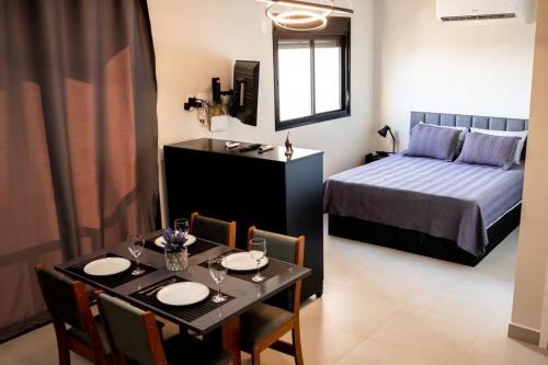 a bedroom with a table and a bed and a dining room at Loft Aconchegante Centro in Dourados