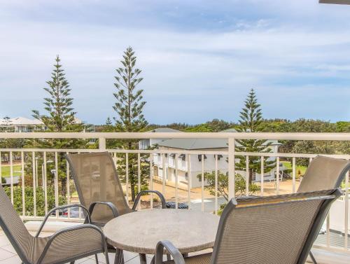a patio with chairs and a table on a balcony at The Pool Resort Kingscliff - Private Apartments by Holiday Management Company in Kingscliff