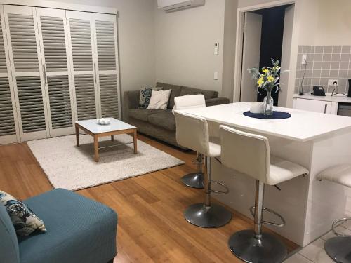 a living room with a white table and a couch at The Pool Resort Kingscliff - Private Apartments by Holiday Management Company in Kingscliff