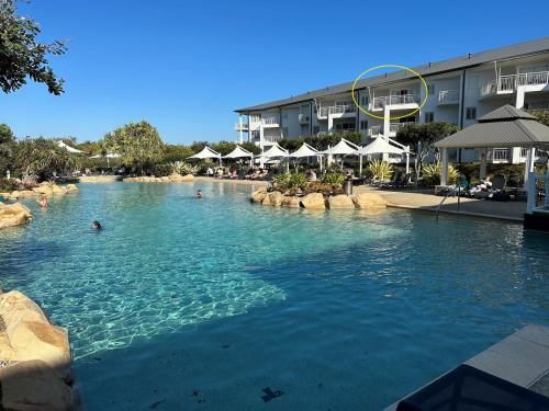 a swimming pool in a resort with people in it at The Pool Resort Kingscliff - Private Apartments by Holiday Management Company in Kingscliff