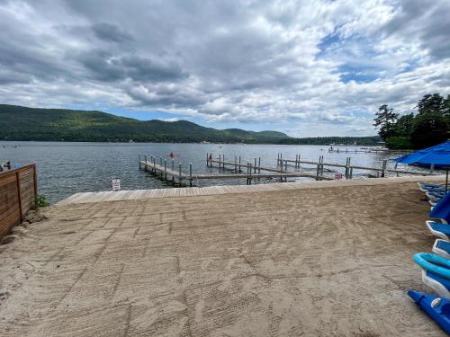 a dock on a body of water with blue umbrellas at Park Lane Motel in Lake George