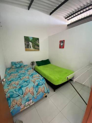 a bedroom with a bed and a green mattress at Acogedor apartamento familiar in Mariquita