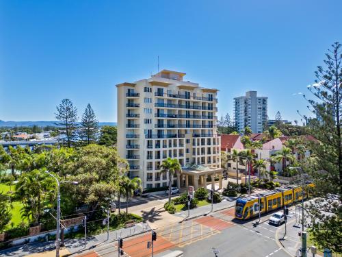 a yellow bus is parked in front of a tall building at Palazzo Colonnades in Gold Coast